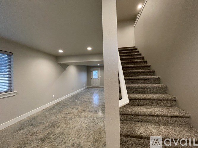 A spacious room with a staircase leading to the upper floor.