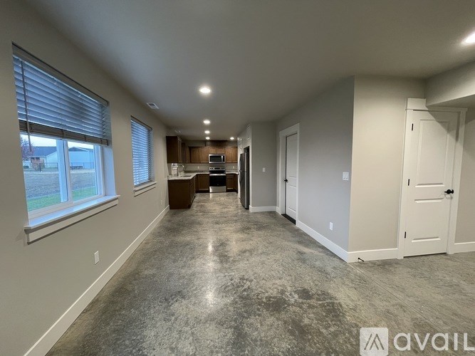 A spacious room with a kitchen area in the background.