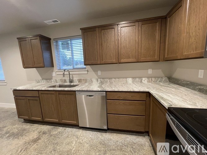 A kitchen with wooden cabinets and a marble countertop.
