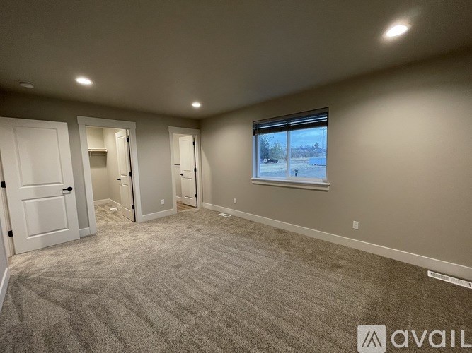A room with a carpeted floor and a window showing a snowy landscape outside.