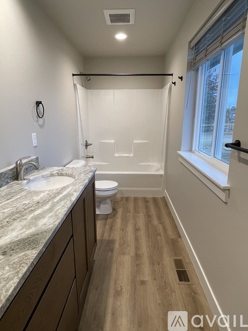 A bathroom with a marble countertop and a walk-in shower.