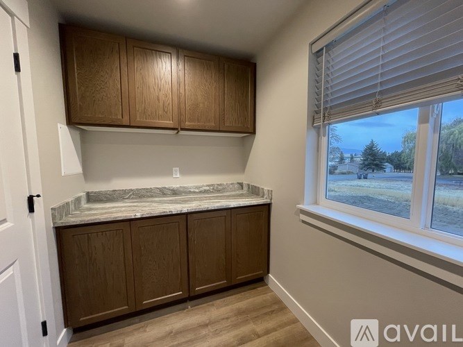 A kitchen with wooden cabinets and a marble countertop.