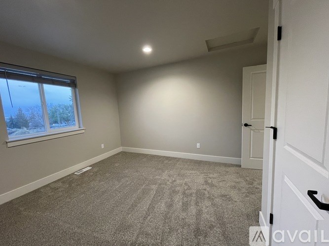 A room with a carpeted floor and a window with a view of the outside.