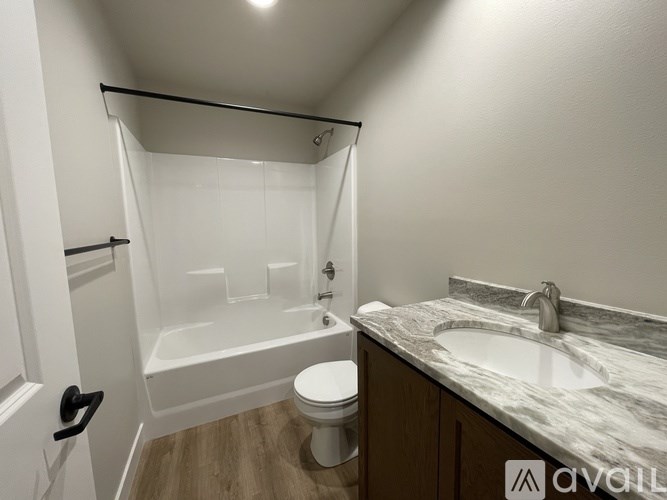 A white bathroom with a toilet, sink, and bathtub.
