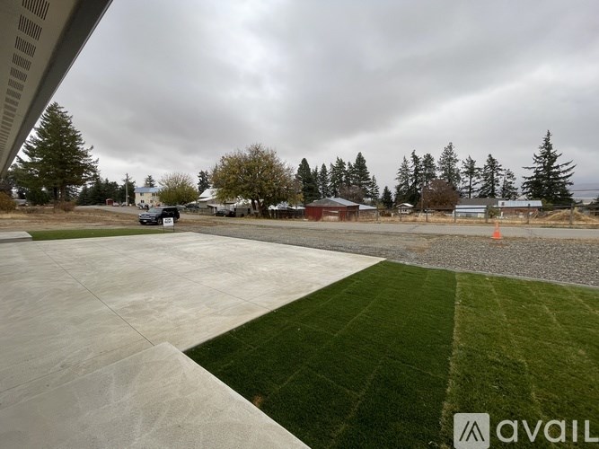 A parking lot with a few cars and a building in the background.