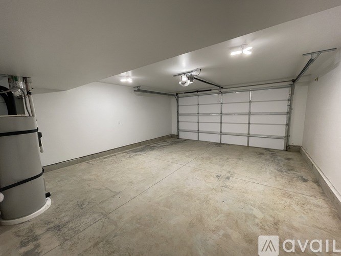 A large empty garage with a white door and a concrete floor.
