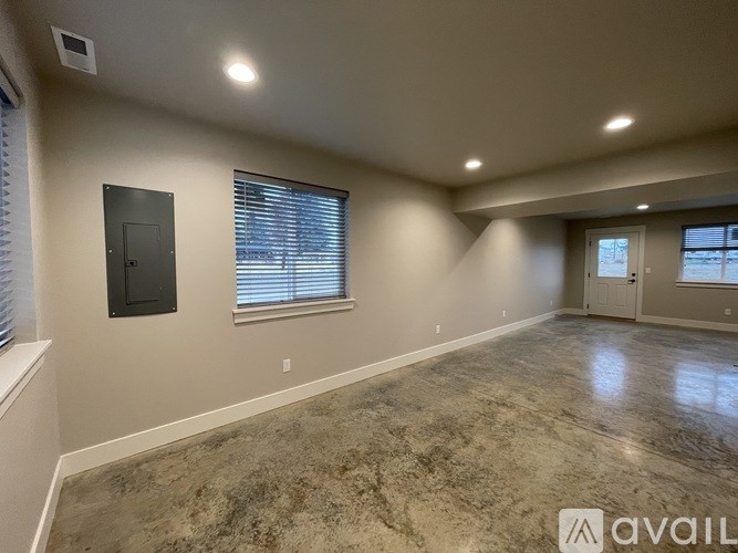 A spacious room with a marble floor and a window with blinds.
