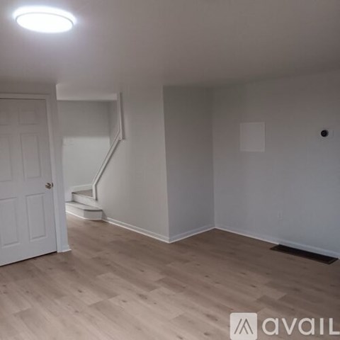 A room with wooden flooring and a white door.