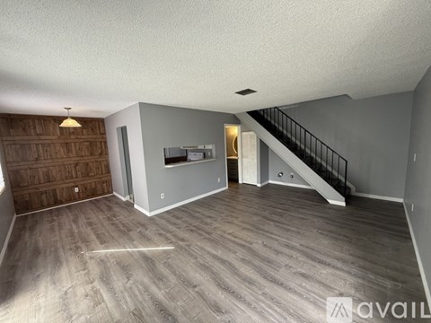 A spacious living room with a staircase leading to the upper floor.