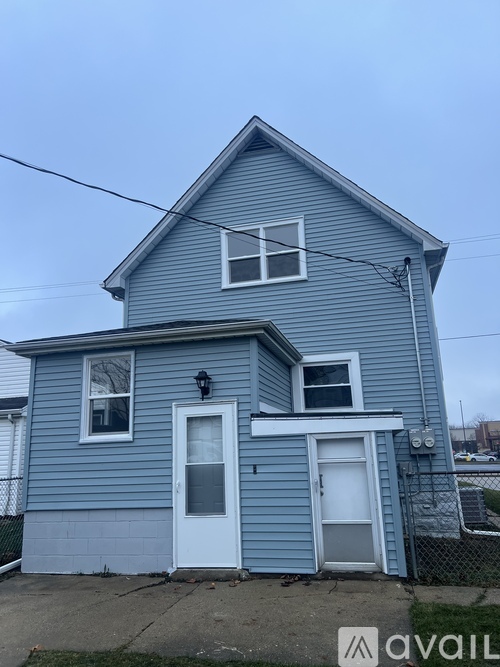 A blue house with a white door and windows.