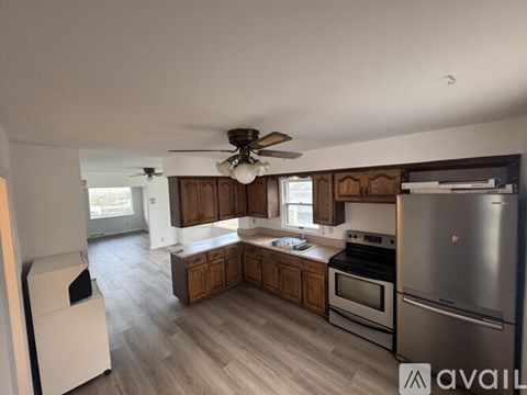 A kitchen with wooden cabinets and a stainless steel refrigerator.