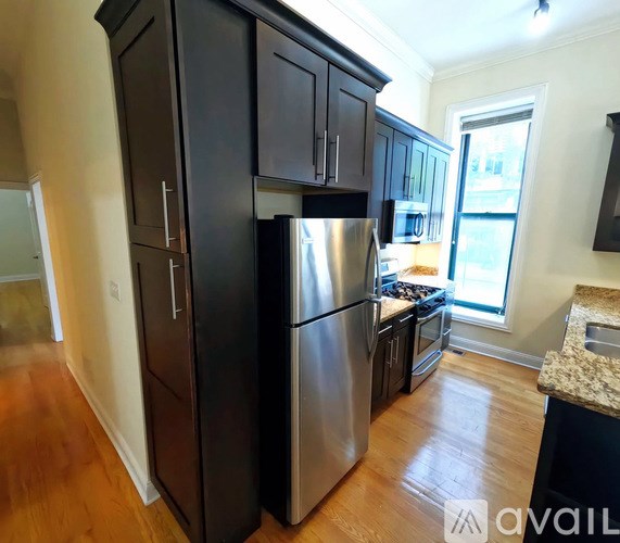 A kitchen with dark wood cabinets and stainless steel appliances.