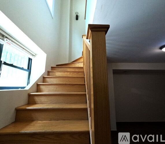 A wooden staircase with a skylight above it.