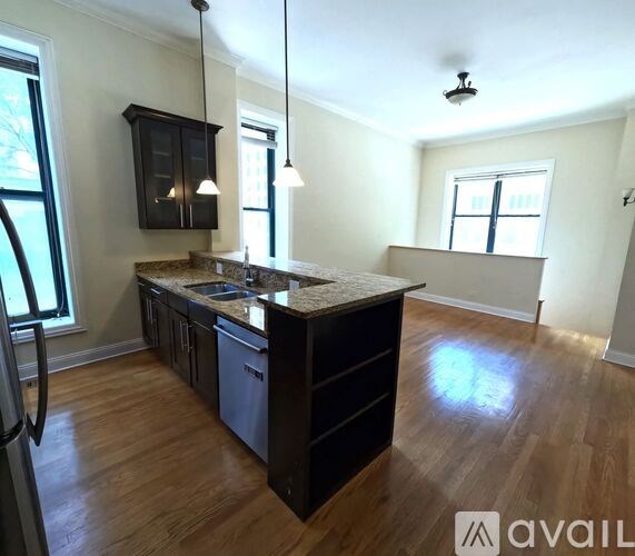 A kitchen with dark wood cabinets and a granite countertop.