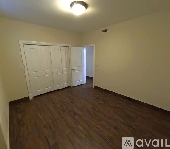 A room with wooden floors and two white doors.