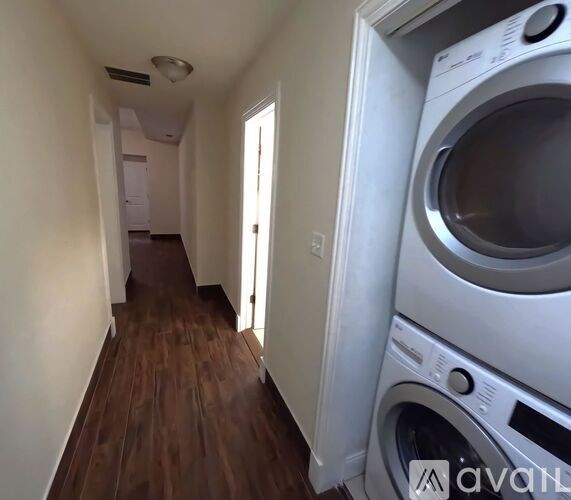 A washing machine is in the doorway of a room.