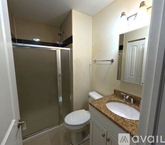 A bathroom with a toilet, sink, and shower.