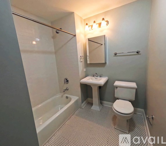 A small bathroom with a toilet, sink, and bathtub.
