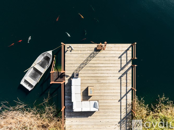 A wooden dock with a boat and a person on it.