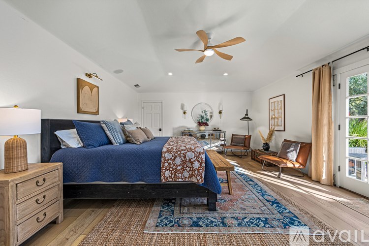 A bedroom with a bed, a dresser, and a ceiling fan.