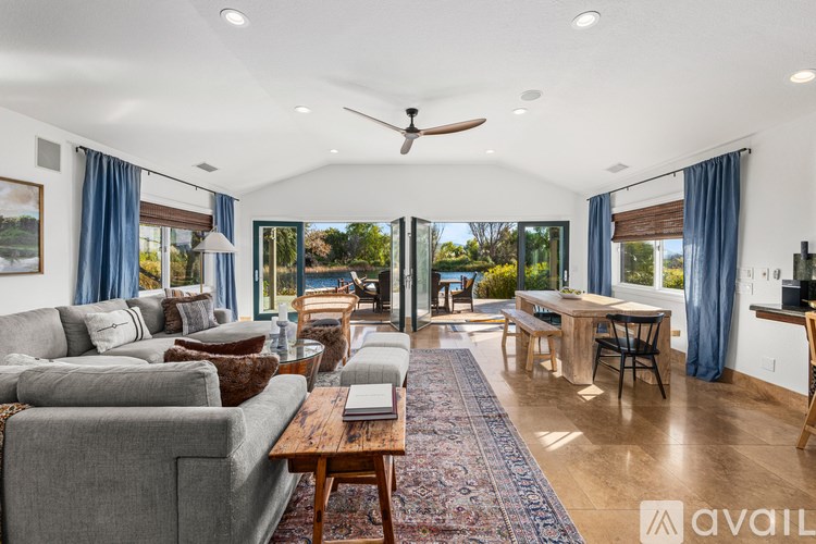A spacious living room with a grey sofa and a wooden coffee table.