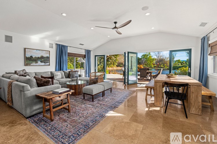 A living room with a couch, a coffee table, and a dining table.