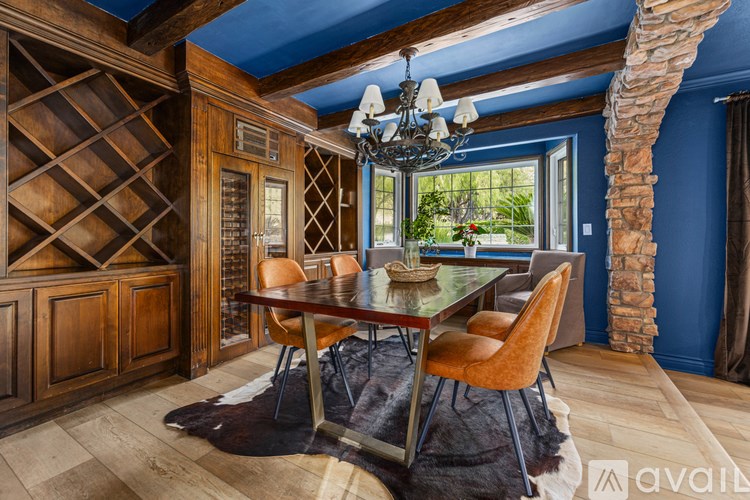 A dining room with a wooden table and chairs.