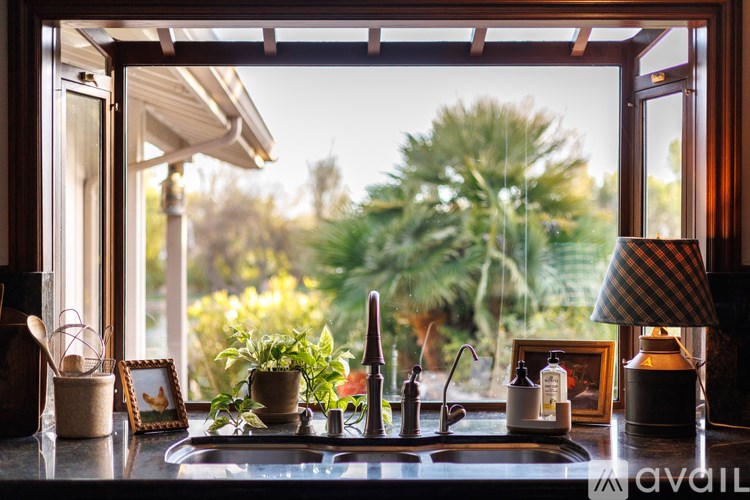 A kitchen sink with a window overlooking a garden.