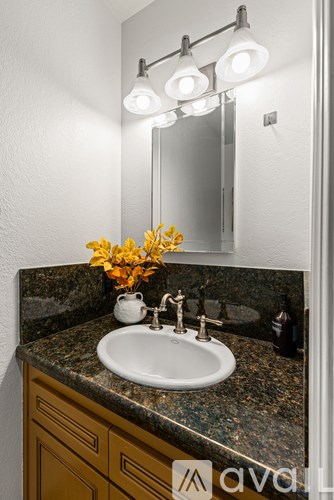 A bathroom sink with a mirror and lights above it.