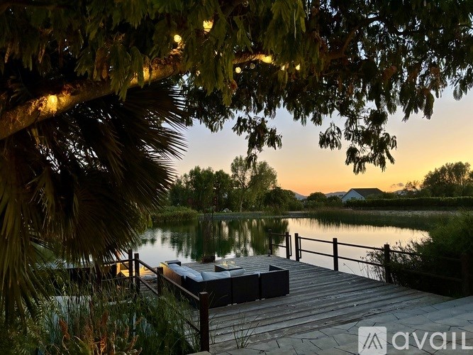 A vase with dried flowers sits on a wooden crate.