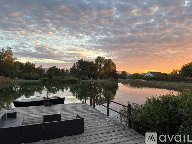 A bowl with flowers sits on a wooden table.