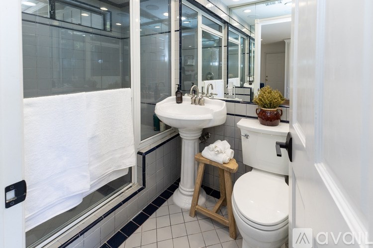 A bathroom with a toilet, sink, and mirror.