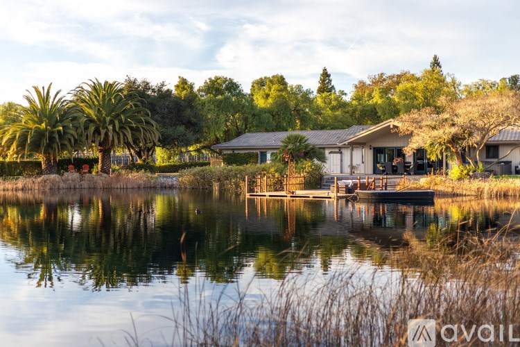 A house is reflected in the still water of a pond.