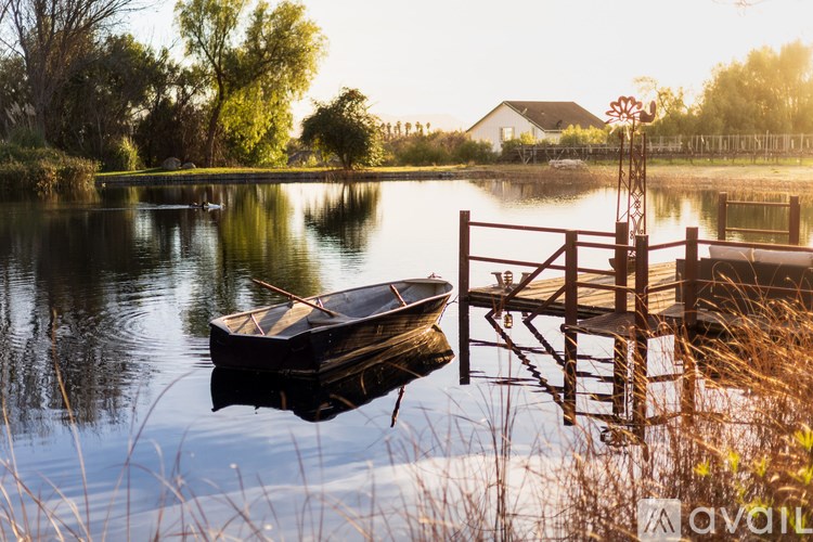 A boat is docked at a wooden dock on a calm lake.