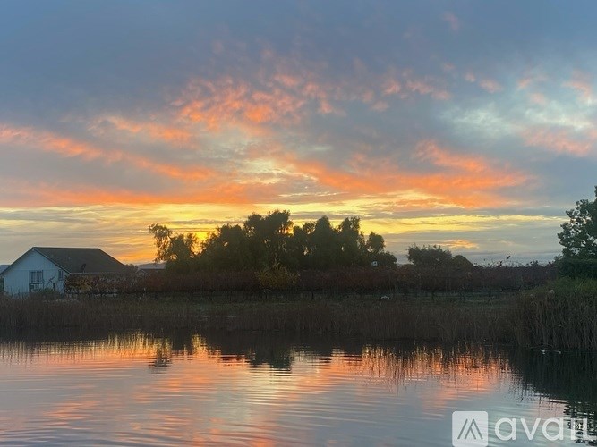 A house is reflected in the water at sunset.