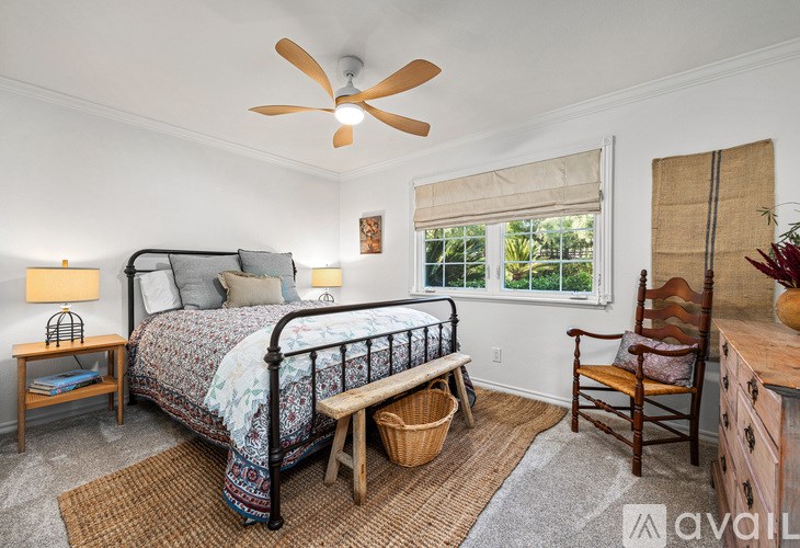 A bedroom with a bed, chair, and window.
