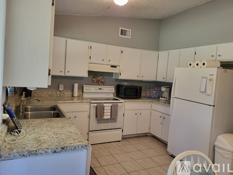 A kitchen with white cabinets and appliances.