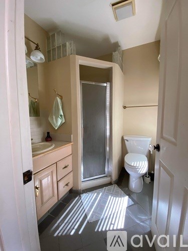 A bathroom with a toilet, sink, and shower.