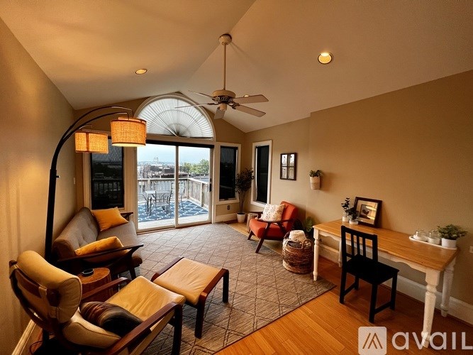 A living room with a ceiling fan and a view of a deck outside.
