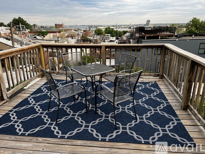 A table and chairs are set up on a deck with a view of the city.