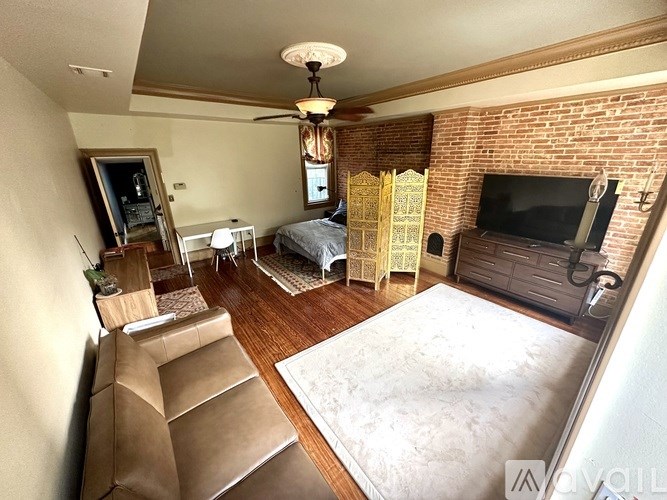 A bedroom with a bed, a couch, and a television.