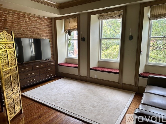 A living room with a brick wall and a television.