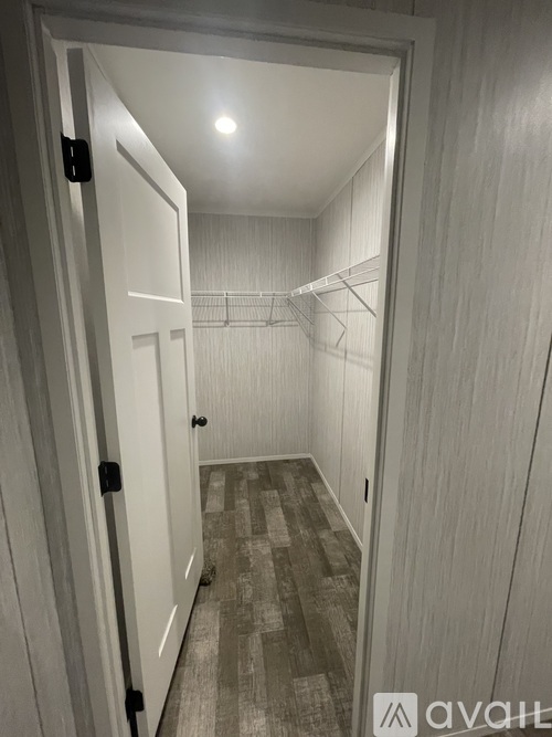 A hallway with a carpeted floor and a light on the ceiling.