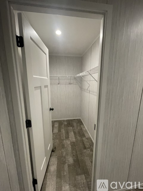 A hallway with a carpeted floor and a light on the ceiling.