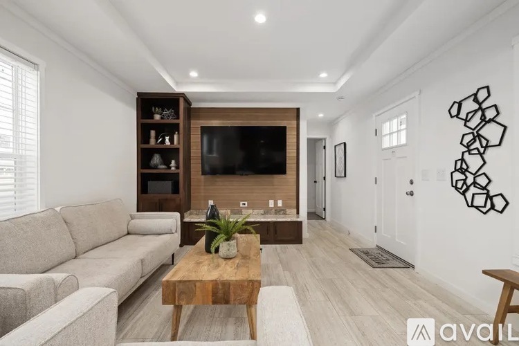 A living room with a wooden coffee table and a grey sofa.