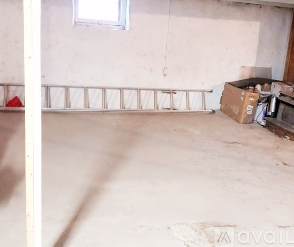 A room with a window and a white wall.