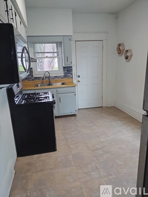 A kitchen with black appliances and a black countertop.
