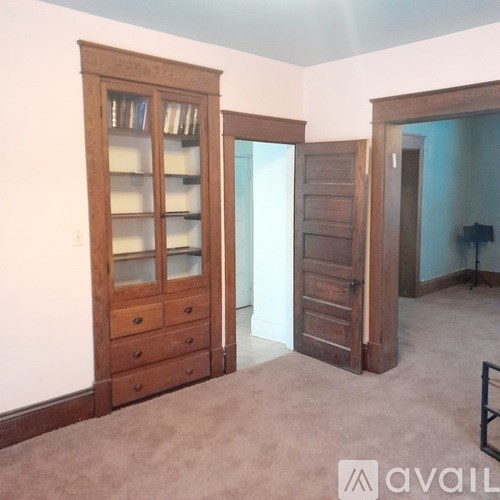 A room with a wooden bookcase and a wooden door.