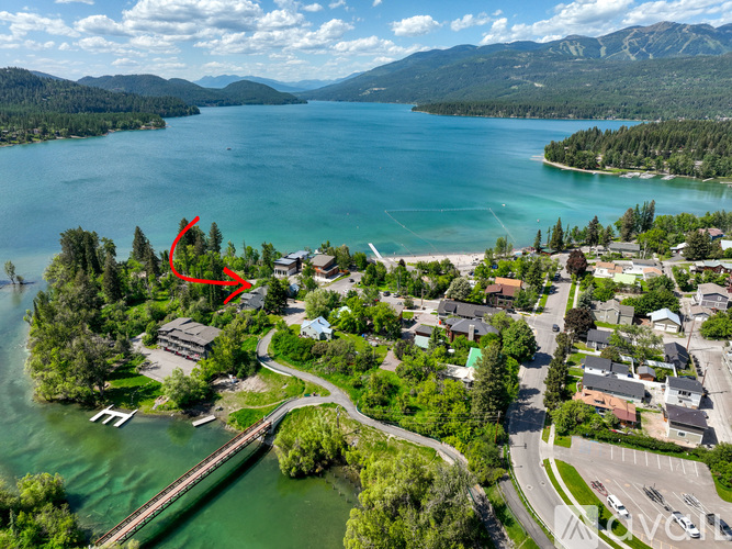 A red arrow points to a house by a lake.