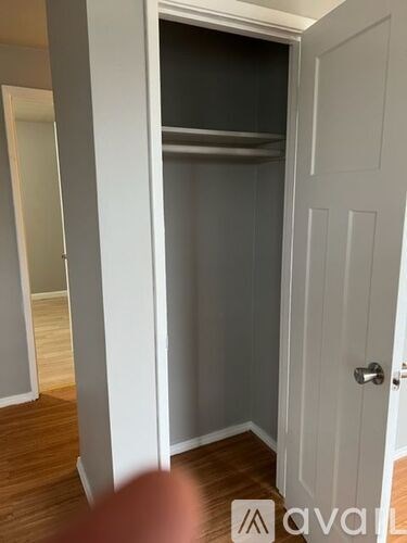 A white door is in a room with a wooden floor.